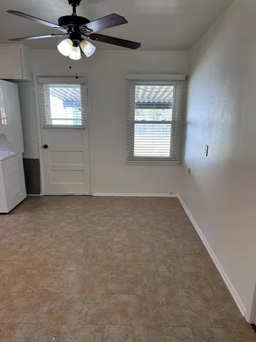 an empty room with windows and fan