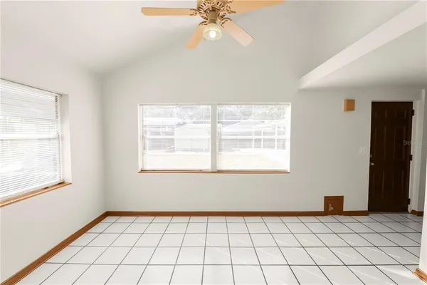 a view of an empty room and window chandelier fan