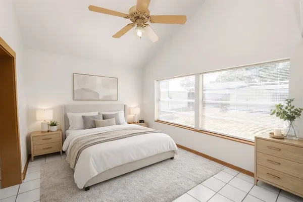 an empty room with windows and fan