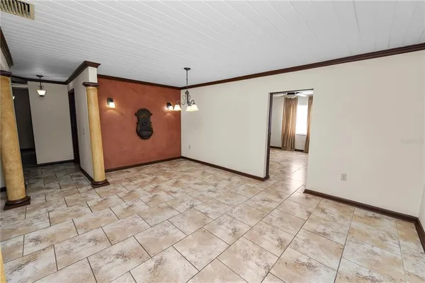 an empty room with windows and ceiling fan