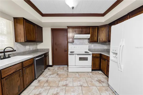 a kitchen with a stove sink and cabinets
