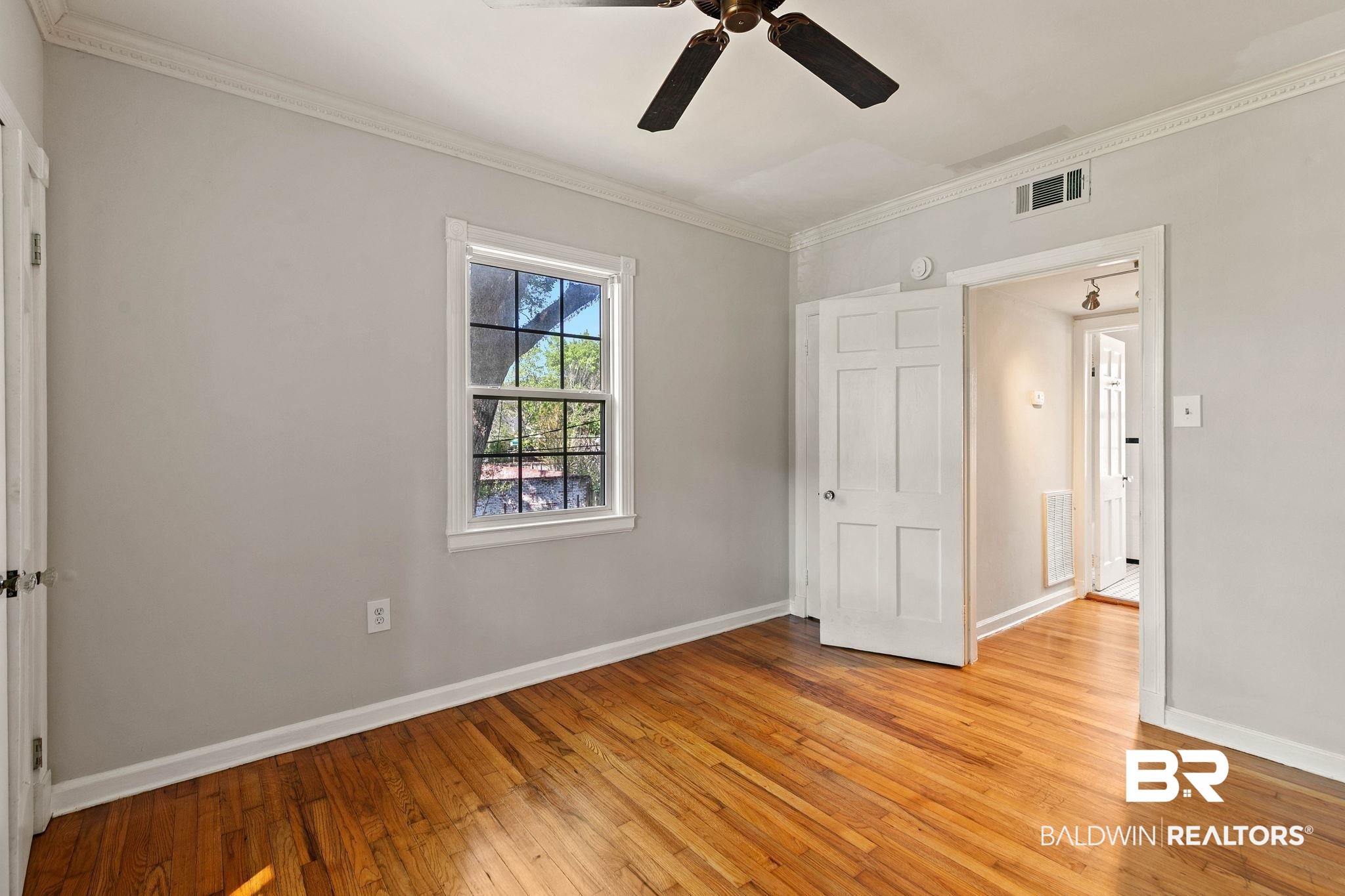 214 Upham Street, Unit 8D Mobile, AL 36607 - Photo 22 of 36 Unfurnished bedroom featuring light wood-style flooring, crown molding, and a ceiling fan