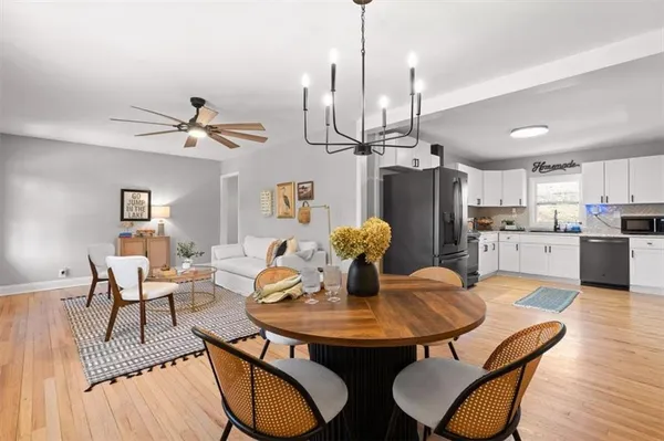 a view of a dining room with furniture a chandelier and wooden floor