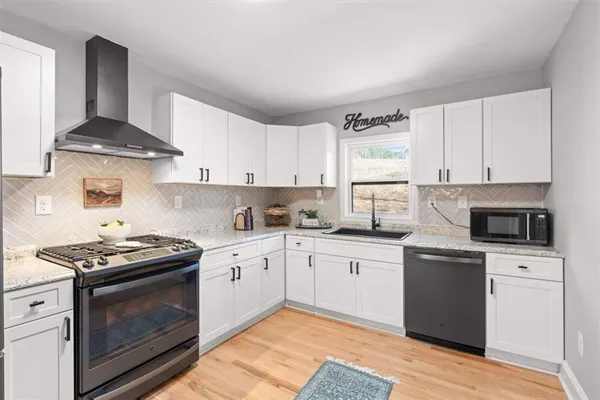 a kitchen with granite countertop white cabinets and white appliances