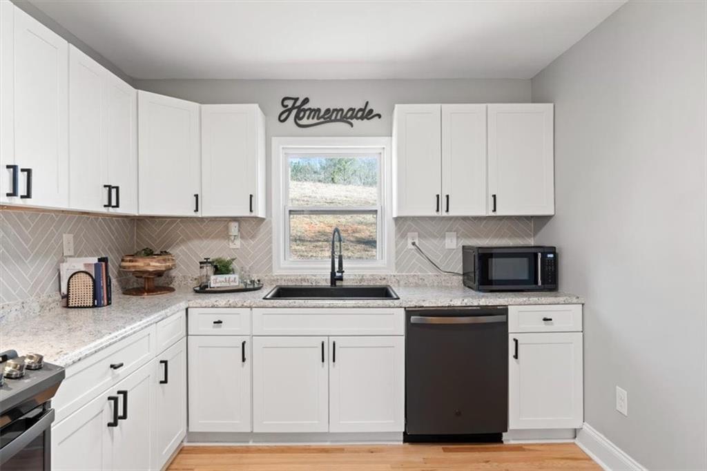 80 Hand Road Bowdon, GA 30108 - Photo 9 of 83 a kitchen with granite countertop white cabinets and white appliances