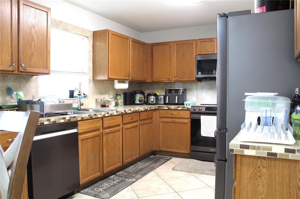115 Willowbay Ridge Street Sanford, FL 32771 - Photo 6 of 28 a kitchen with stainless steel appliances granite countertop a sink stove and refrigerator