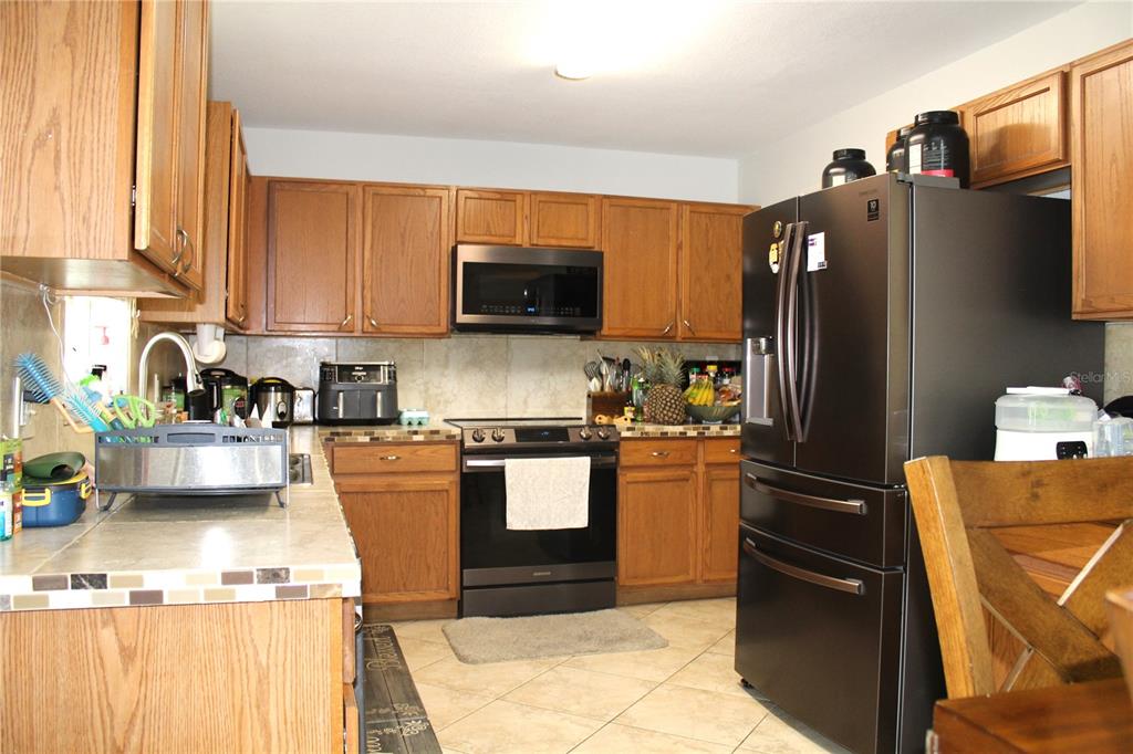 115 Willowbay Ridge Street Sanford, FL 32771 - Photo 7 of 28 a kitchen with stainless steel appliances granite countertop a refrigerator stove and sink