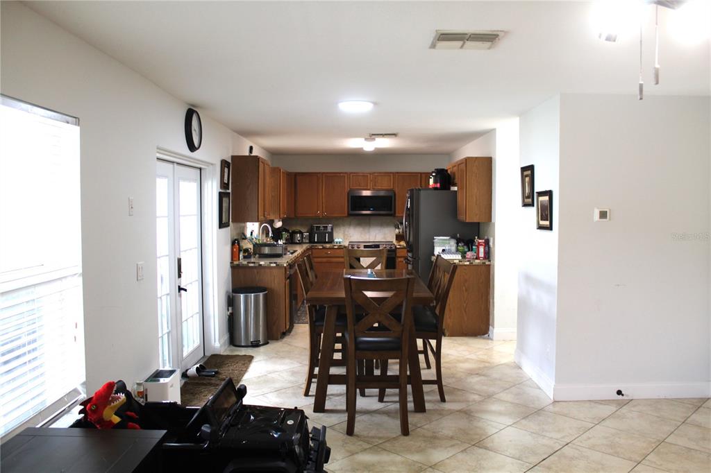 115 Willowbay Ridge Street Sanford, FL 32771 - Photo 8 of 28 a kitchen with a refrigerator and a dining table