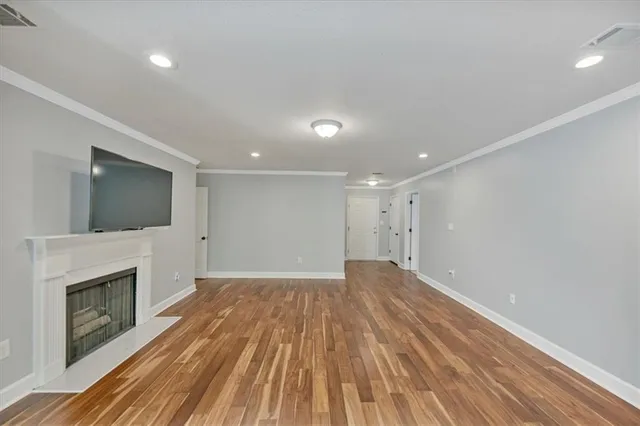 a view of empty room with wooden floor and fireplace