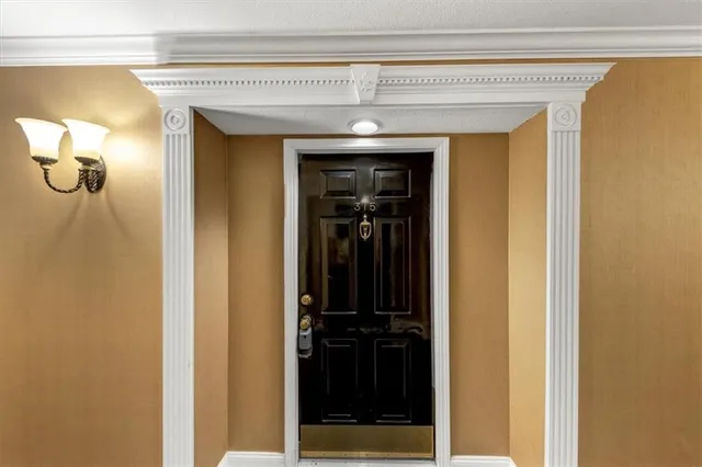 a view of an empty room with wooden floor fireplace and a window