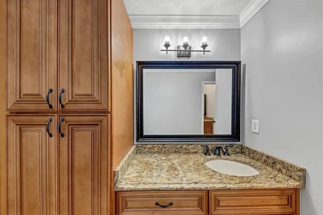 a bathroom with a granite countertop sink a toilet and a mirror