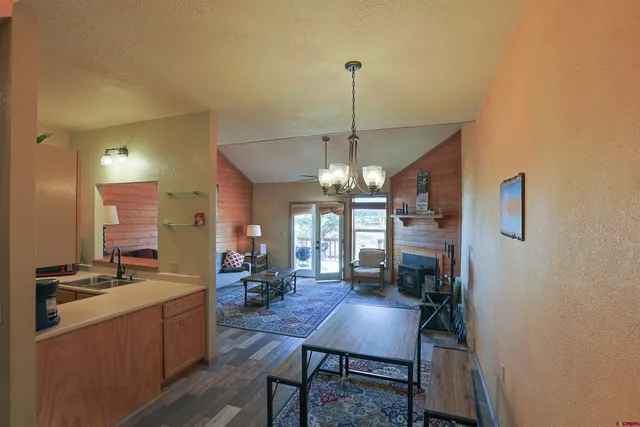 a view of a dining room filled with furniture and a chandelier
