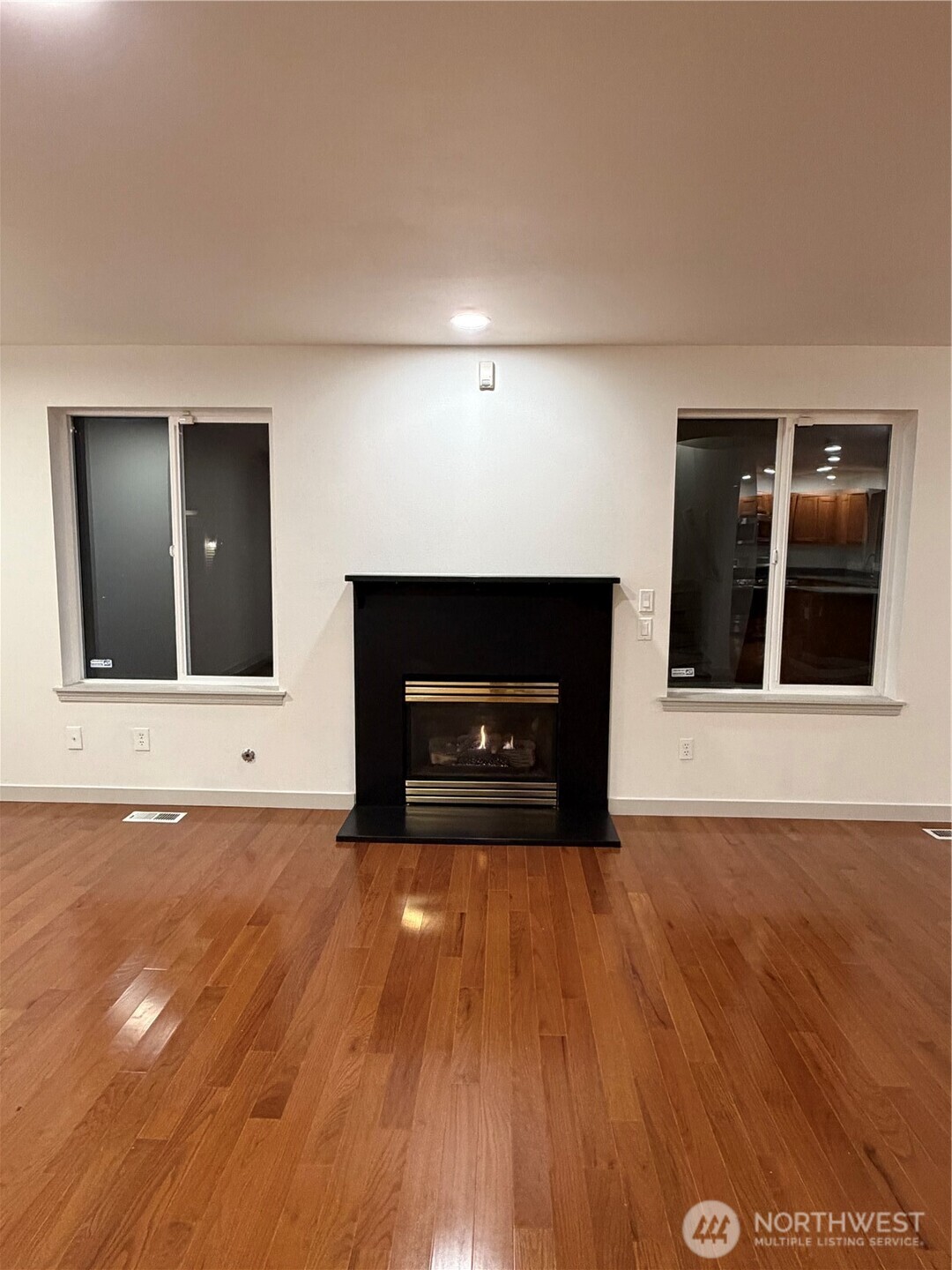 15409 51st Place West Edmonds, WA 98026 - Photo 4 of 14 a view of an empty room with wooden floor fire place and windows