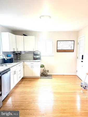 a large white kitchen with kitchen island a sink a stove a counter top space and a window