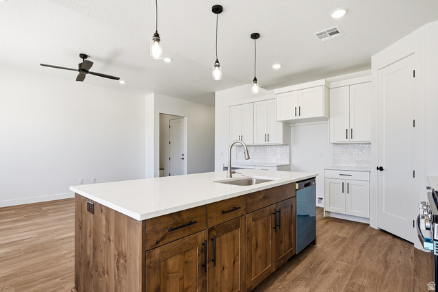4978 North 75 East Enoch, UT 84721 - Photo 10 of 60 Dual tone kitchen with dual tone cabinets, a kitchen island with sink, pendant lighting, ceiling fan, and dark wood-style flooring