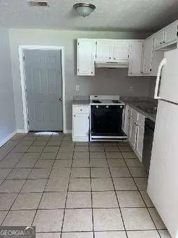 a kitchen with a stove a refrigerator and cabinets