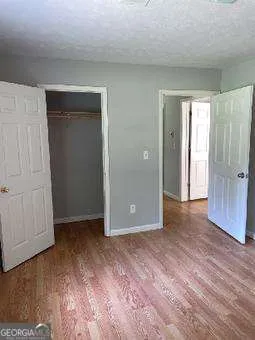 an empty room with wooden floor and closet area