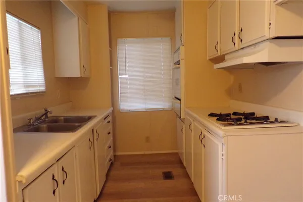 a kitchen with a sink stove top oven and cabinets