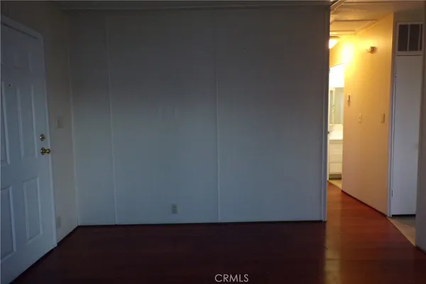 an empty room with wooden floor and a window