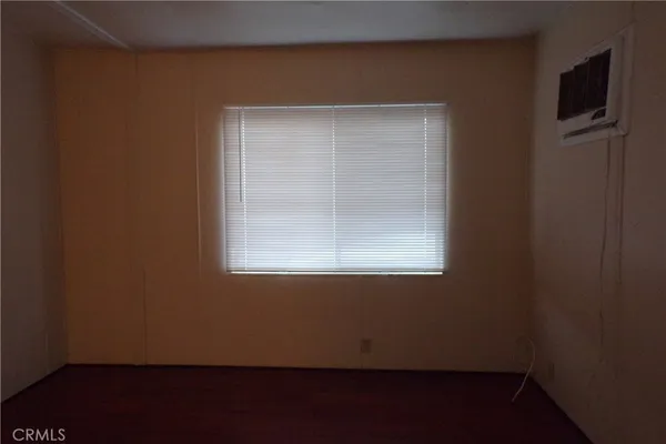 a view of a small space with wooden floor and a window
