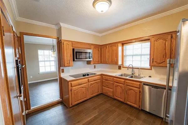 a kitchen with a sink a window and stainless steel appliances