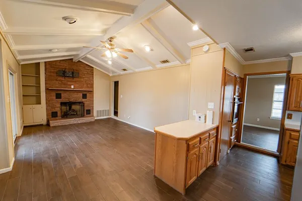 a view of a room with wooden floor and a ceiling fan