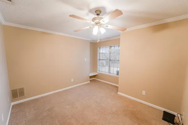 an empty room with chandelier fan and windows