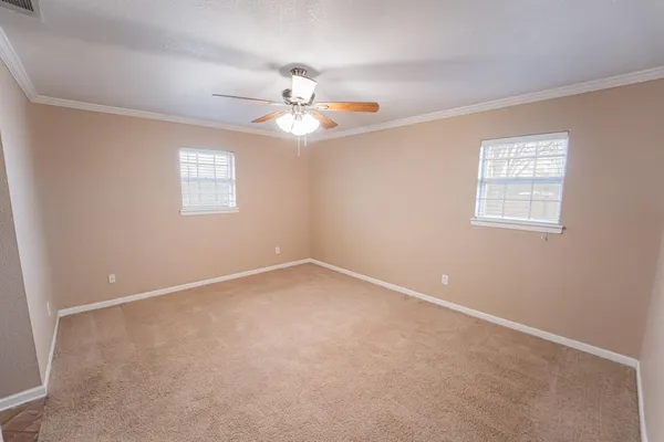 an empty room with a window and a fan