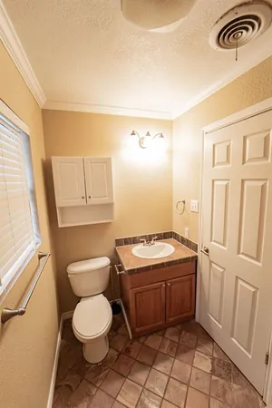 a bathroom with a toilet a sink and a window