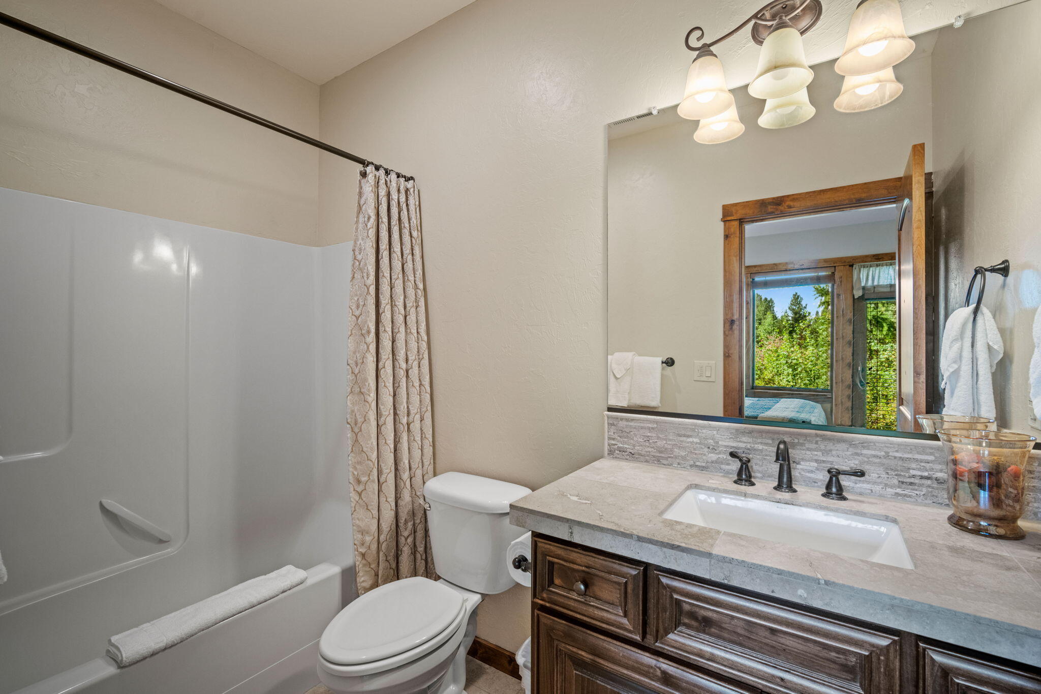 56508 Dancing Rock Loop, Unit 22 Bend, OR 97707 - Photo 33 of 69 a bathroom with a granite countertop sink toilet a mirror and shower