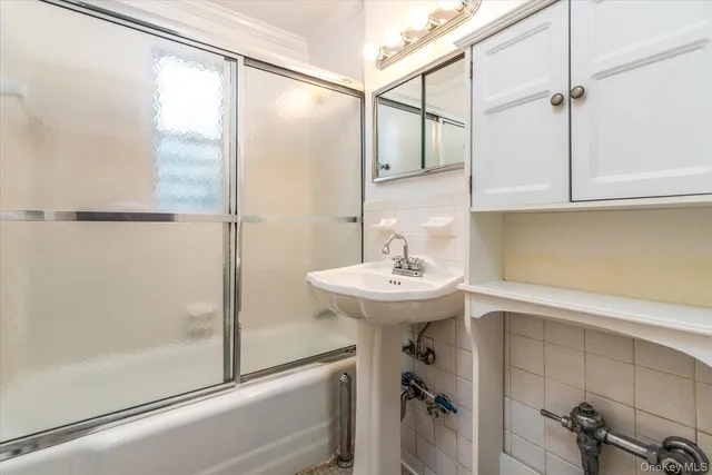 a bathroom with a sink and mirror with bathtub