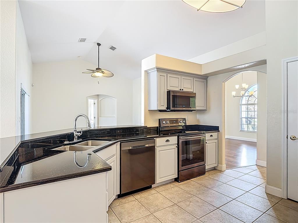 3189 Bayview Lane St. Cloud, FL 34772 - Photo 15 of 41 a kitchen with a sink stove and microwave