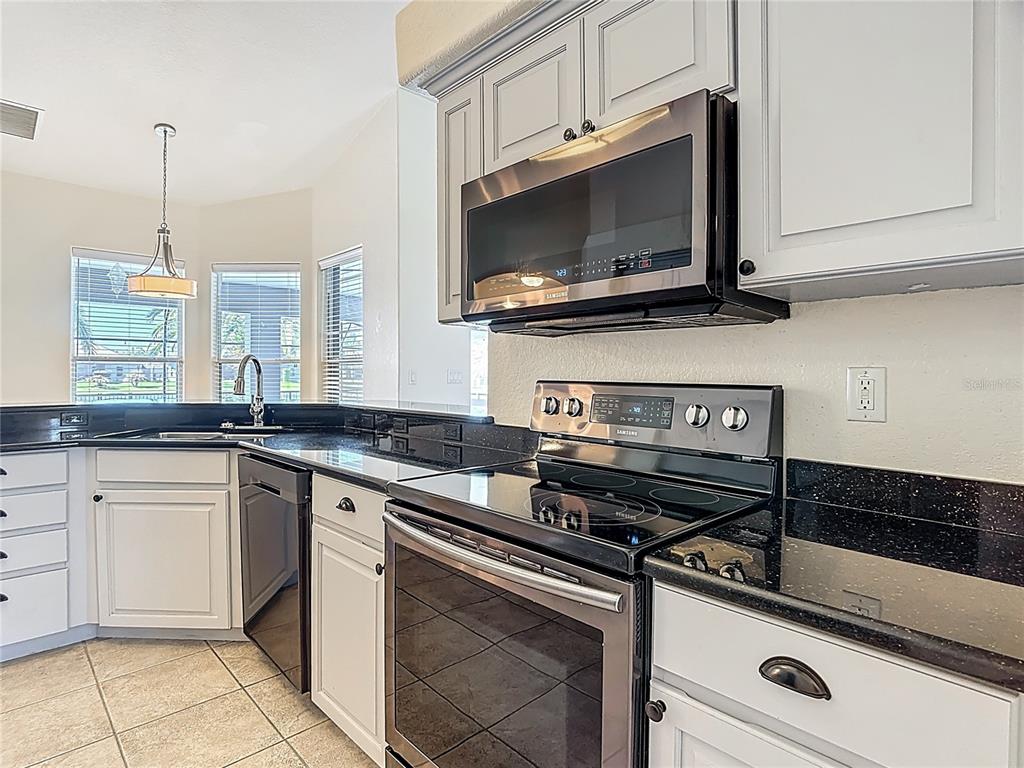 3189 Bayview Lane St. Cloud, FL 34772 - Photo 17 of 41 a kitchen with stainless steel appliances granite countertop a sink and a stove