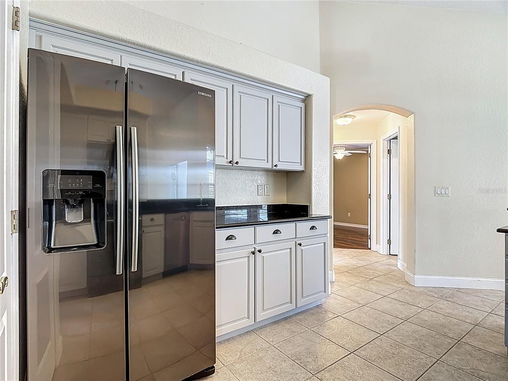 3189 Bayview Lane St. Cloud, FL 34772 - Photo 18 of 41 a kitchen with stainless steel appliances granite countertop a refrigerator and a sink