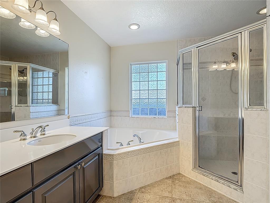 3189 Bayview Lane St. Cloud, FL 34772 - Photo 23 of 41 a bathroom with a bathtub shower sink vanity and a mirror