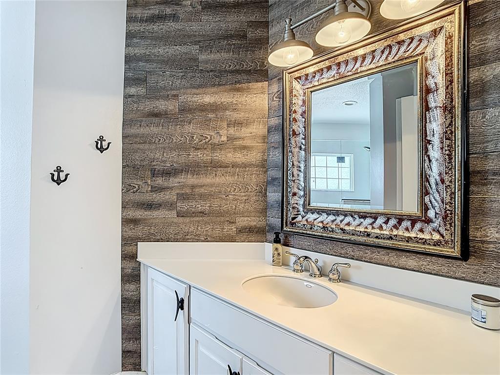 3189 Bayview Lane St. Cloud, FL 34772 - Photo 25 of 41 a bathroom with a granite countertop sink and a mirror