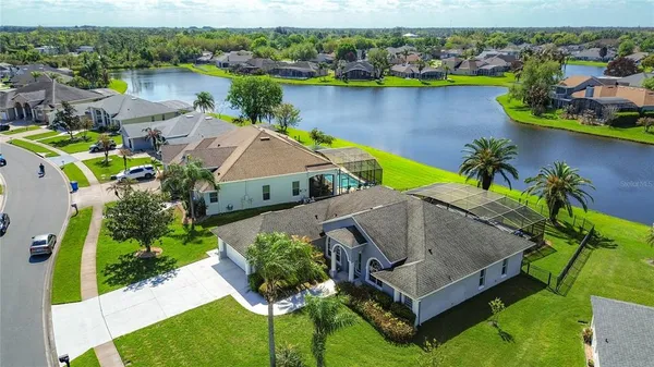 an aerial view of a house with a garden and lake view