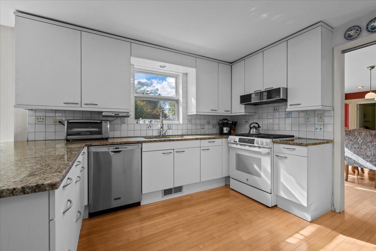 1140 Ridge Road Highland Park, IL 60035 - Photo 13 of 31 a kitchen with stainless steel appliances granite countertop a stove a sink and white cabinets