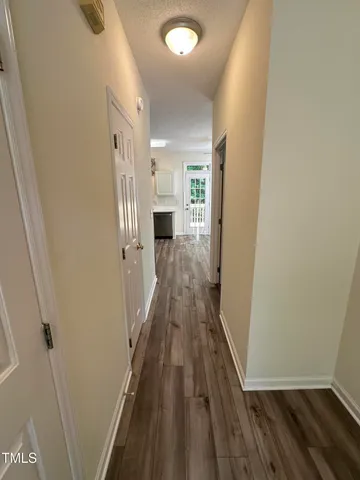 a view of a hallway with wooden floor and staircase