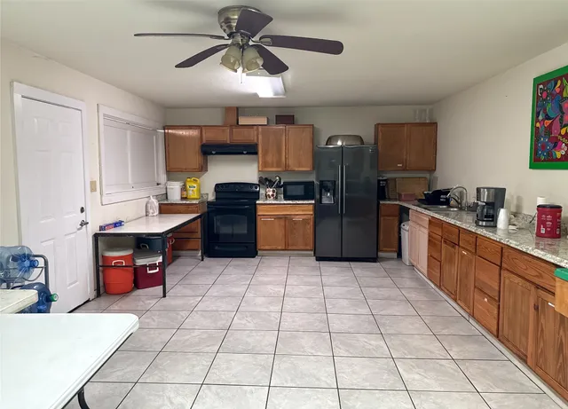 a kitchen with stainless steel appliances kitchen island granite countertop a sink and cabinets