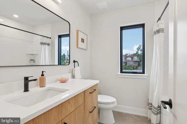 a bathroom with a sink a toilet and mirror
