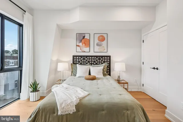 a bedroom with a bed and a painting on the wall