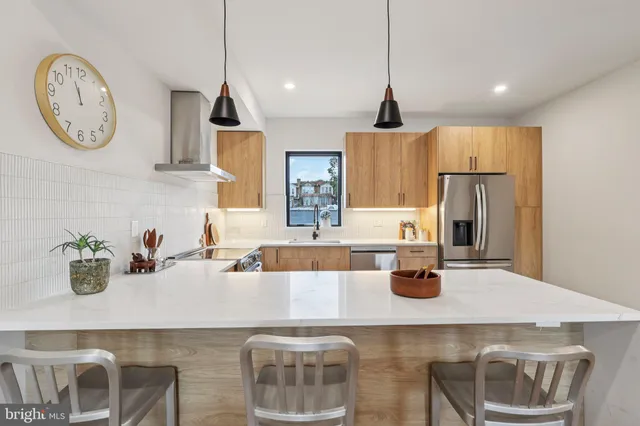 a kitchen with kitchen island granite countertop a sink a stove and refrigerator