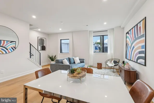 a view of a dining room with furniture a kitchen and wooden floor