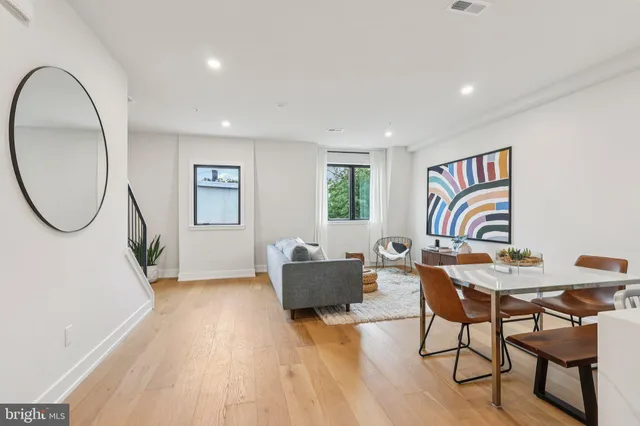 a living room with furniture a table and wooden floor