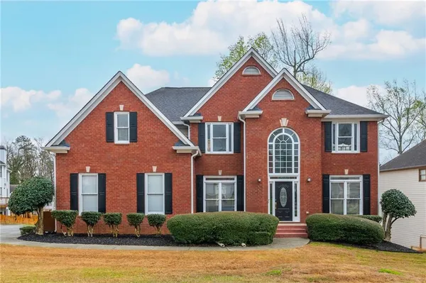 a front view of a house with yard and green space
