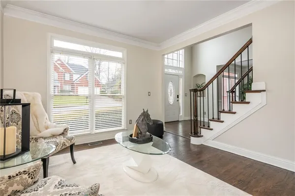 a kitchen with white cabinets and wooden floor