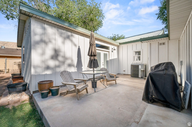 236 West 300 South Hurricane, UT 84737 - Photo 64 of 76 Expansive concrete patio area, featuring white board-and-batten siding and a green metal roof
