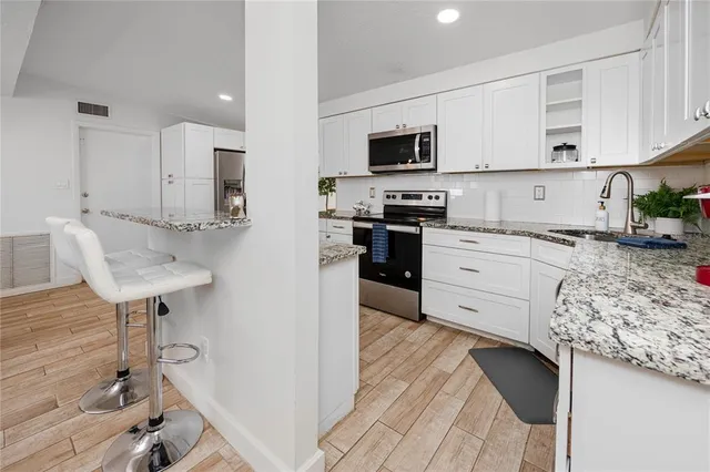 a kitchen with stainless steel appliances kitchen island granite countertop a sink and cabinets