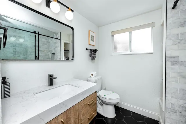 a bathroom with a toilet a sink and mirror